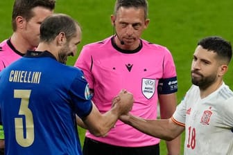 Im Gegensatz zum gut gelaunten italienischen Kapitän Giorgio Chiellini scheint Spaniens Jordi Alba nach dem Münzwurf unzufrieden zu sein.