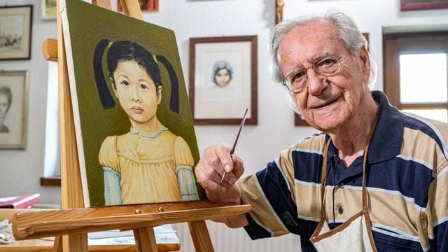 Schauspieler Wilfried Klaus in seinem Atelier neben einem seiner Gemälde.