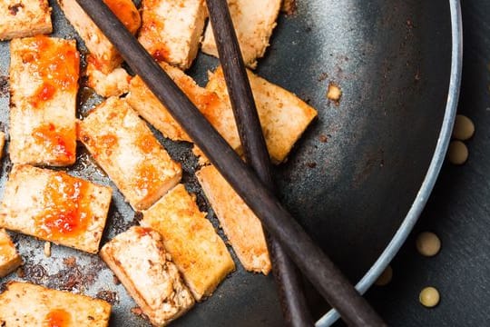 In Sojasauce marinierter und gebratener Tofu wird noch knuspriger, wenn man zuvor Flüssigkeit herauspresst.