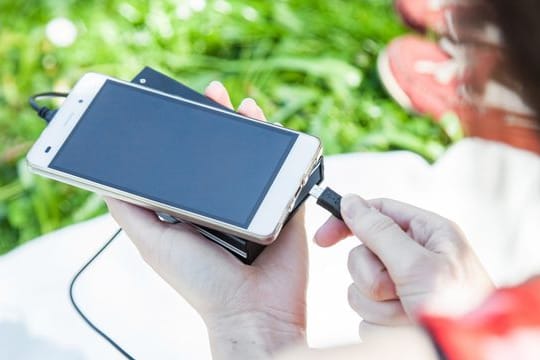Ein Nutzer mit Powerbank und Smartphone: Bei der Nutzung müssen Sie einiges beachten.
