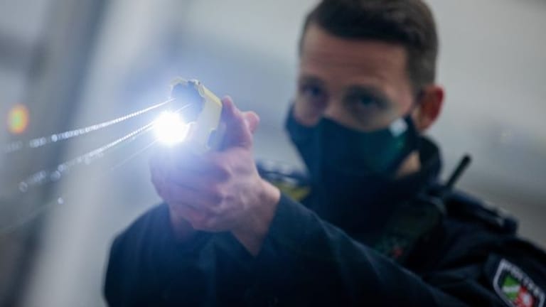 Ein Polizeibeamter demonstriert einen Schuss mit einem Taser