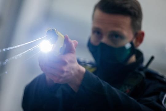 Ein Polizeibeamter demonstriert einen Schuss mit einem Taser