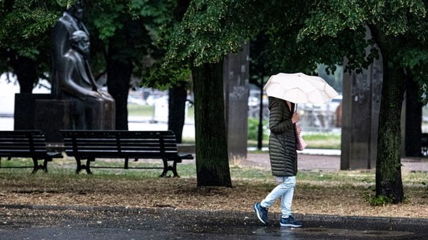Eine Passantin geht bei Regen durch Berlin-Mitte
