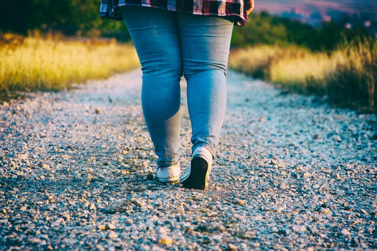 Frau mit kräftigen Beinen auf Schotterweg: Das Lipödem kann die Beweglichkeit einschränken.