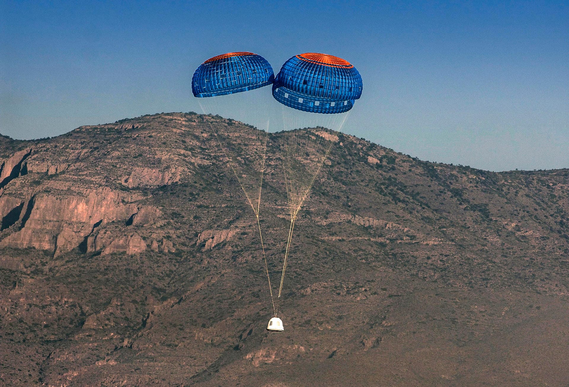 Bei der Rückkehr zur Erde wird die bemannte Kapsel von drei Fallschirmen gebremst.