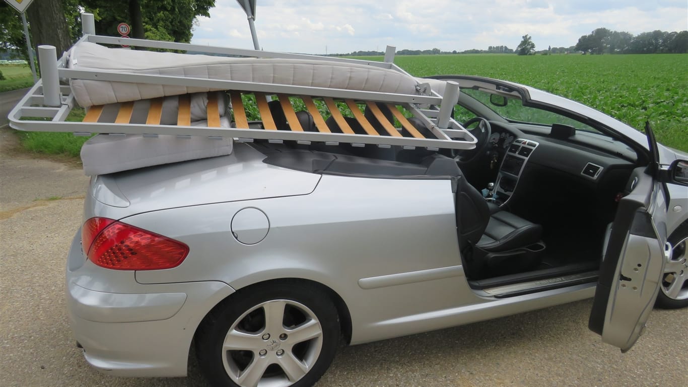 Ein Bett liegt auf einem Cabrio: Ein Mann hat so sein Bett transportiert.
