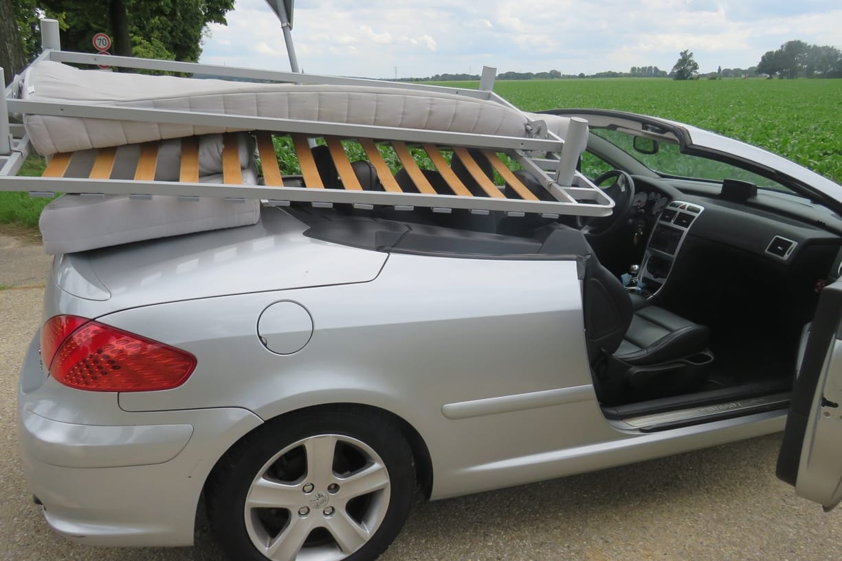 Ein Bett liegt auf einem Cabrio: Ein Mann hat so sein Bett transportiert.