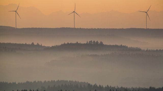 Windräder werden am Morgen durch die aufgehende Sonne angestrahlt