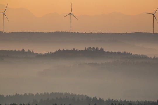 Windräder werden am Morgen durch die aufgehende Sonne angestrahlt