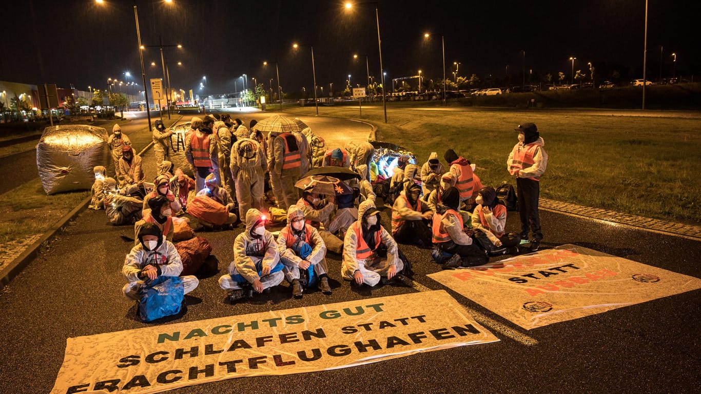 "Nachts gut schlafen statt Frachtflughafen" steht auf einem Banner: Die Aktivisten fordern einen Ausbaustopp des Frachtflughafens, ein Nachtflugverbot und eine Verkehrswende.