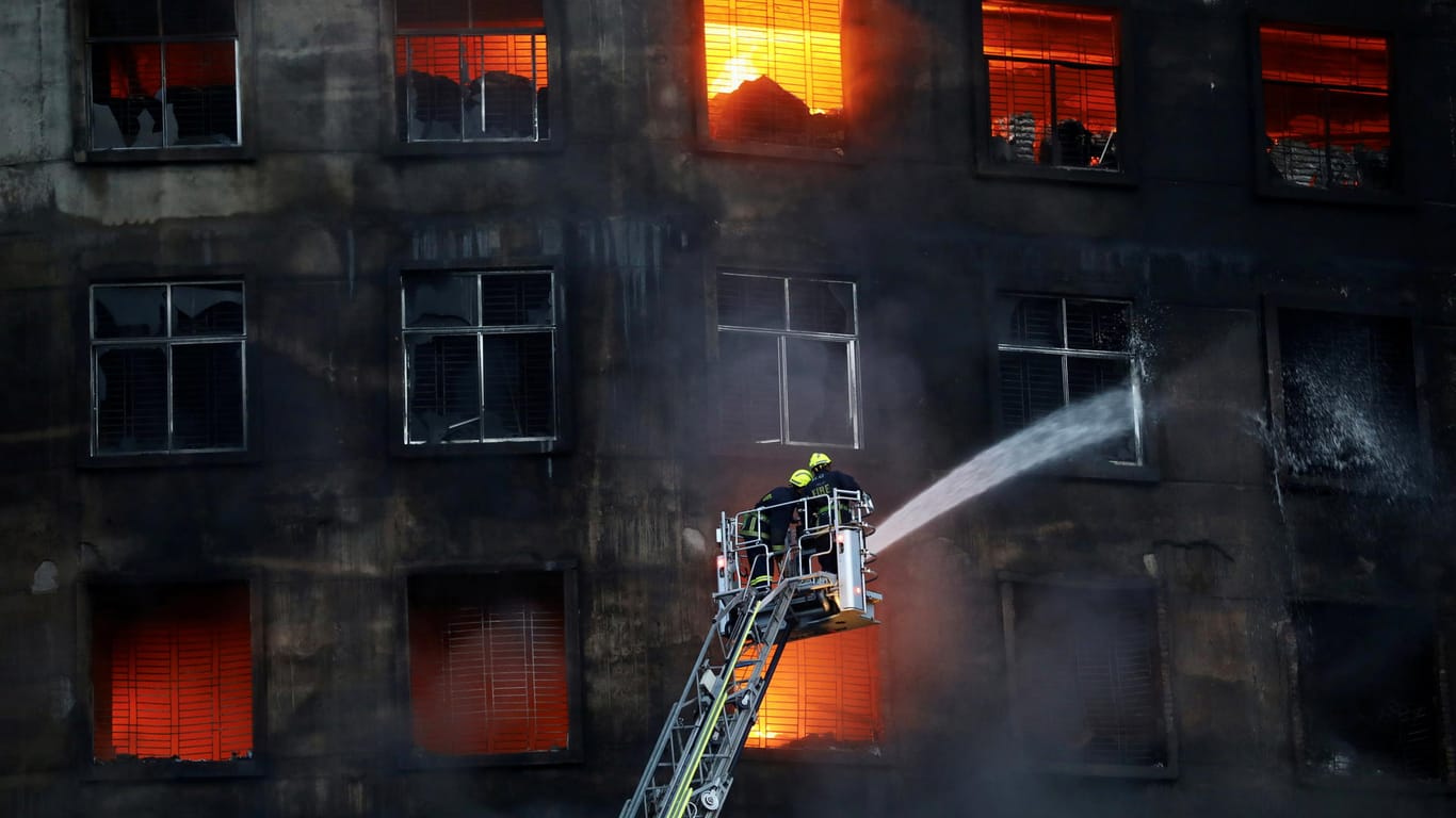 Firefighters work at the scene of a fire on the outskirts of Dhaka