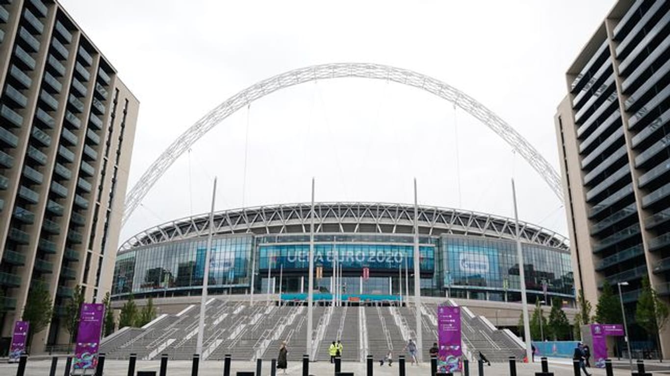 Passanten gehen über den Platz vor dem Wembley-Stadion.