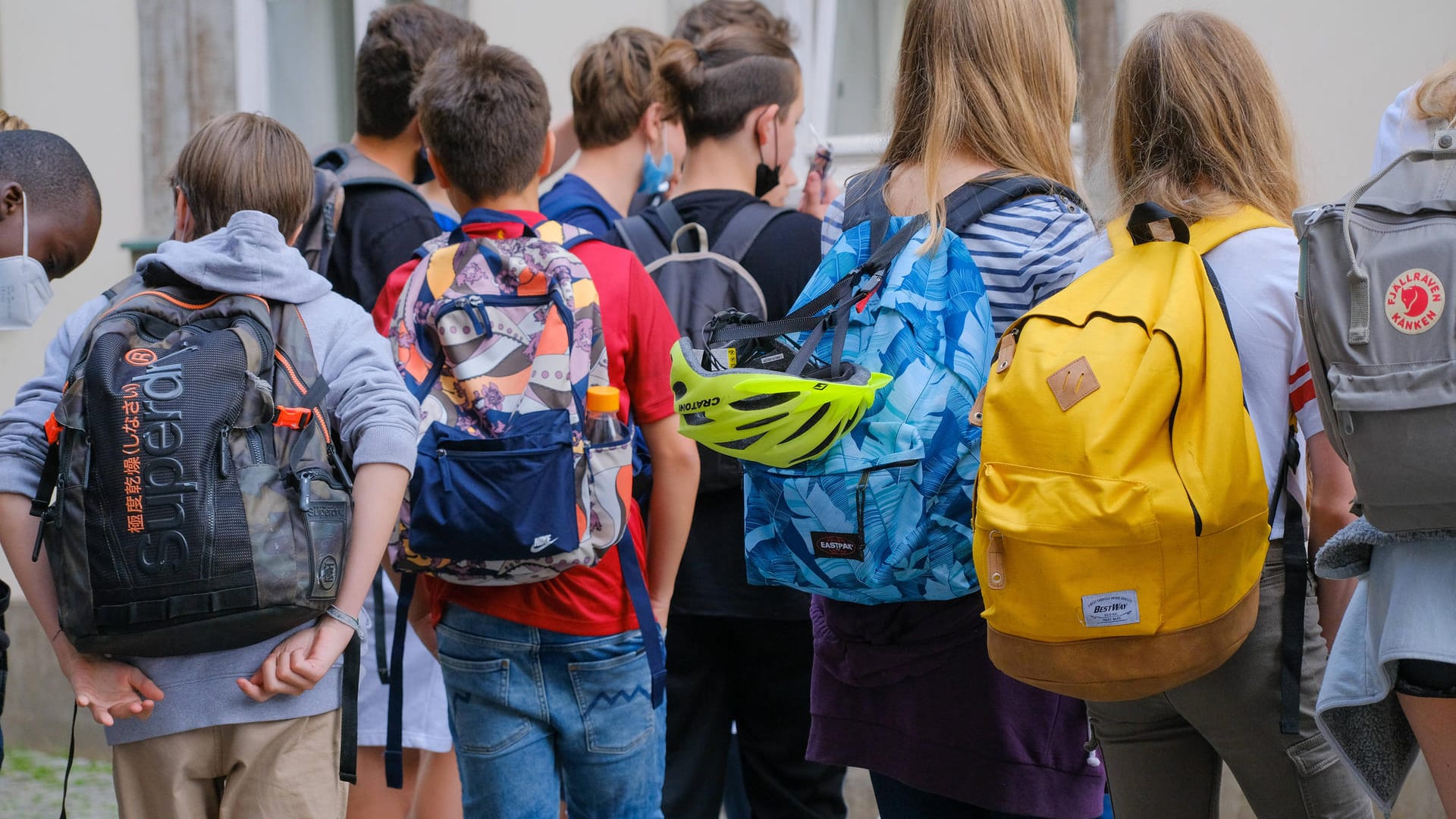 Kinder auf dem Weg in die Schule (Symbolbild). Politiker warnen vor den Auswirkungen einer neue Welle auf Jugendliche.