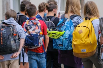 Kinder auf dem Weg in die Schule (Symbolbild). Politiker warnen vor den Auswirkungen einer neue Welle auf Jugendliche.