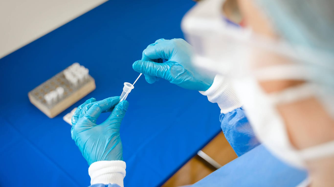 Eine Labortechnikerin bereitet eine Ampulle vor, um auf eine Coronainfektion zu testen (Archivbild). Derzeit wird noch nicht nach mehreren Varianten in Proben gesucht.
