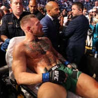 Der verletzte UFC-Kämpfer Conor McGregor wird nach seiner Niederlage auf einer Trage abtransportiert.