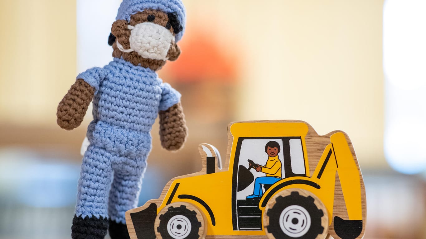 Spielzeug, das nach Aussagen von Mitarbeiterinnen des Museums anti-rassistisch gestaltet sein soll, steht im Spielzeugmuseum Nürnberg auf einem Tisch. Es handelt sich um eine Puppe, die einen Krankenpfleger darstellen soll, und einen Holzbagger mit Fahrer.