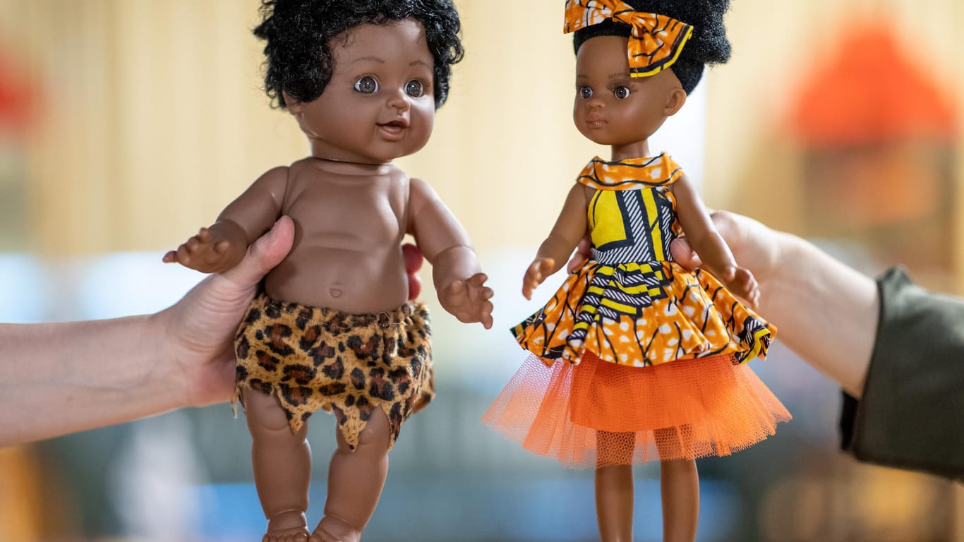 Zwei Puppen werden im Spielzeugmuseum Nürnberg gehalten. Die Puppe links im Bild hat schwarze Haut und trägt nichts als einen Lendenschurz. Sie habe aber die Gesichtszüge einer hellhäutigen Puppe, sagt eine Mitarbeiterin des Spielzeugmuseums. Die Puppe rechts hingegen wirke modern.