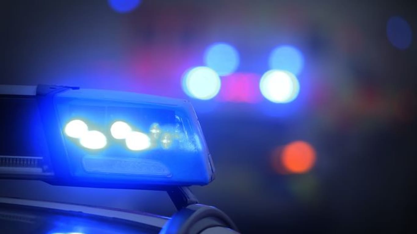 Ein Blaulicht leuchtet auf dem Dach eines Polizeifahrzeugs: Ein aggressiver 34 Jahre alter Mann soll in Berlin-Schöneberg einen Fahrradfahrer vom Rad geschubst und verletzt haben.