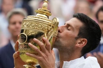 Wimbledon-Sieger Novak Djokovic küsst seine Trophäe.