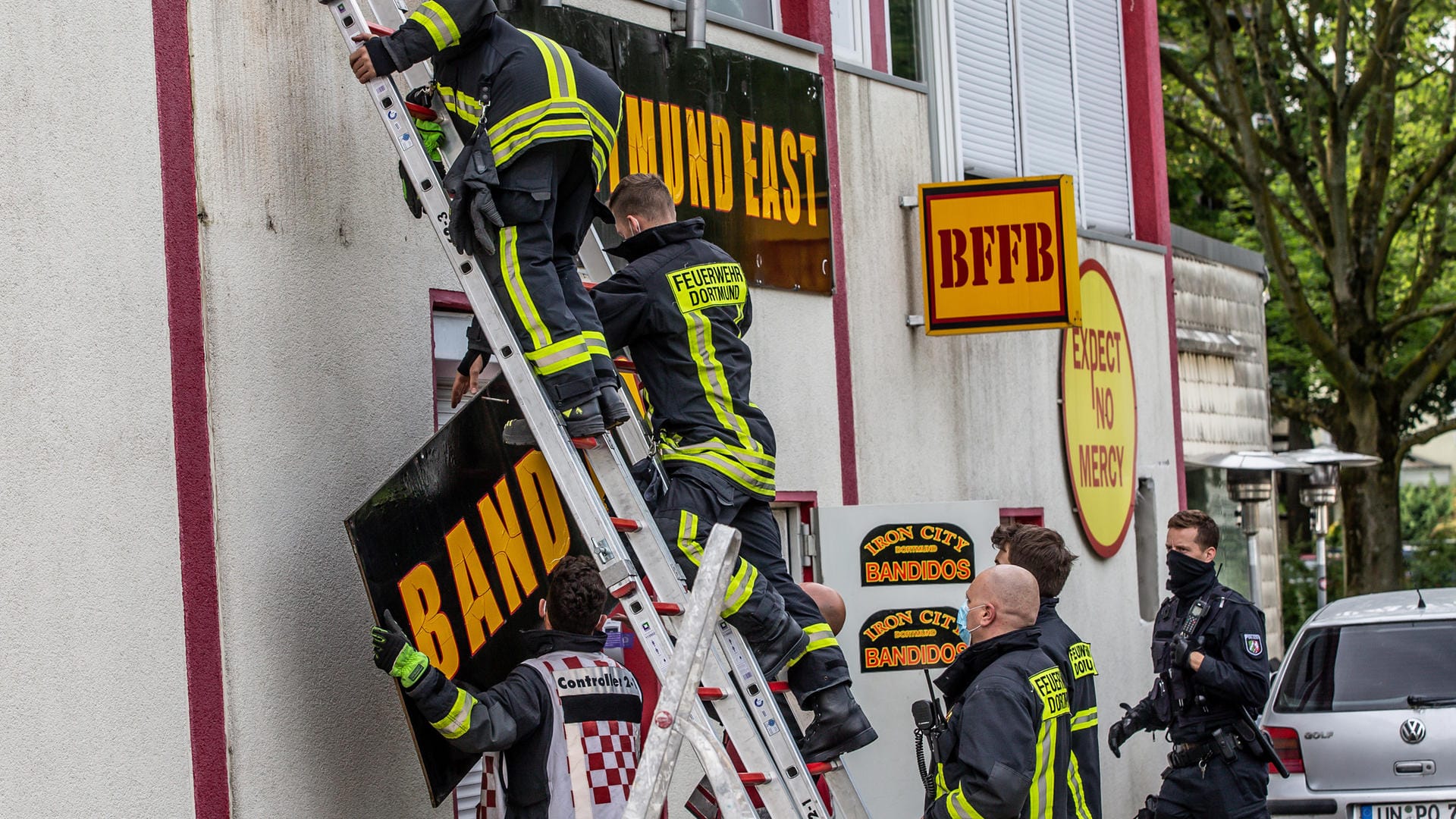 Feuerwehrleute entfernen unter Polizeischutz ein Schild am Vereinsheim der Rockergruppe "Bandidos": Innenminister Seehofer (CSU) hatte die "Bandidos MC Federation West Central" verboten.