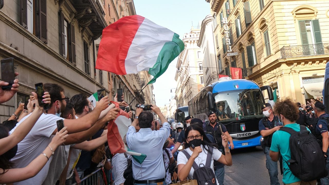Fans jubeln dem Bus der italienischen Fußballnationalmannschaft zu, der kaum durch die Straßen Roms kommt.