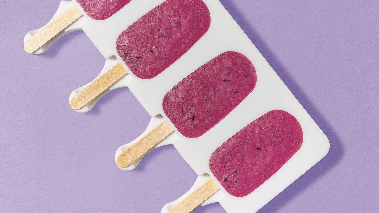 Für Joghurt-Blaubeere-Popsicles werden Blaubeeren, Joghurt, Zucker und Traubenzucker schön cremig gemixt.