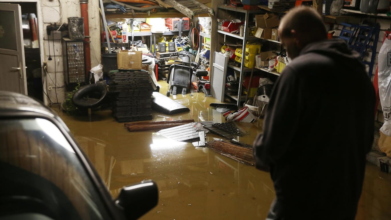 Ein Hausbesitzer steht in seiner überfluteten Garage: Der Wetterdienst warnt weiterhin vor starken Regenfällen in der Region.