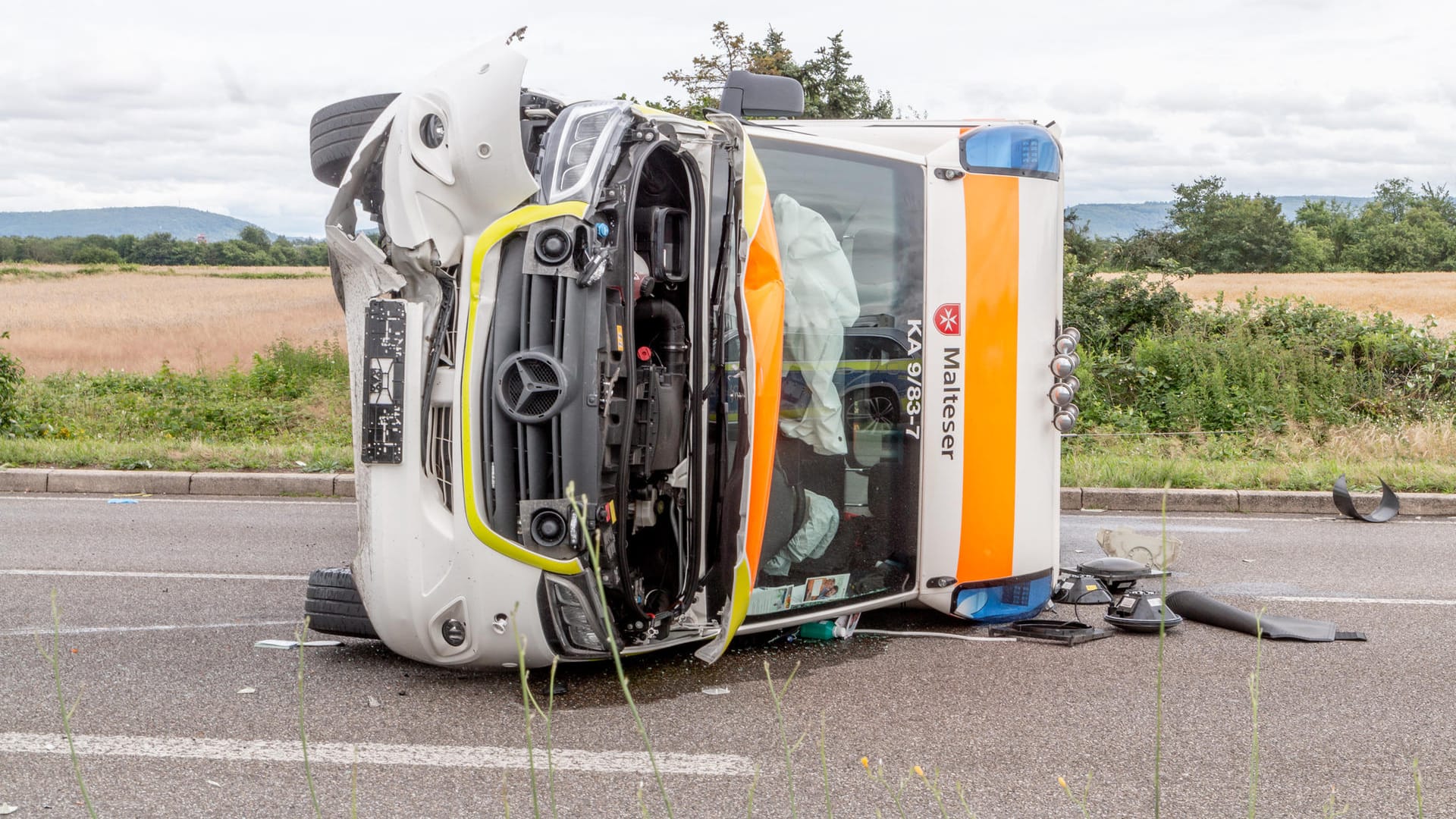 Der umgekippte Rettungswagen liegt nach dem Unfall schwer beschädigt auf der Straße: Vier Menschen wurden bei dem Zusammenstoß verletzt.