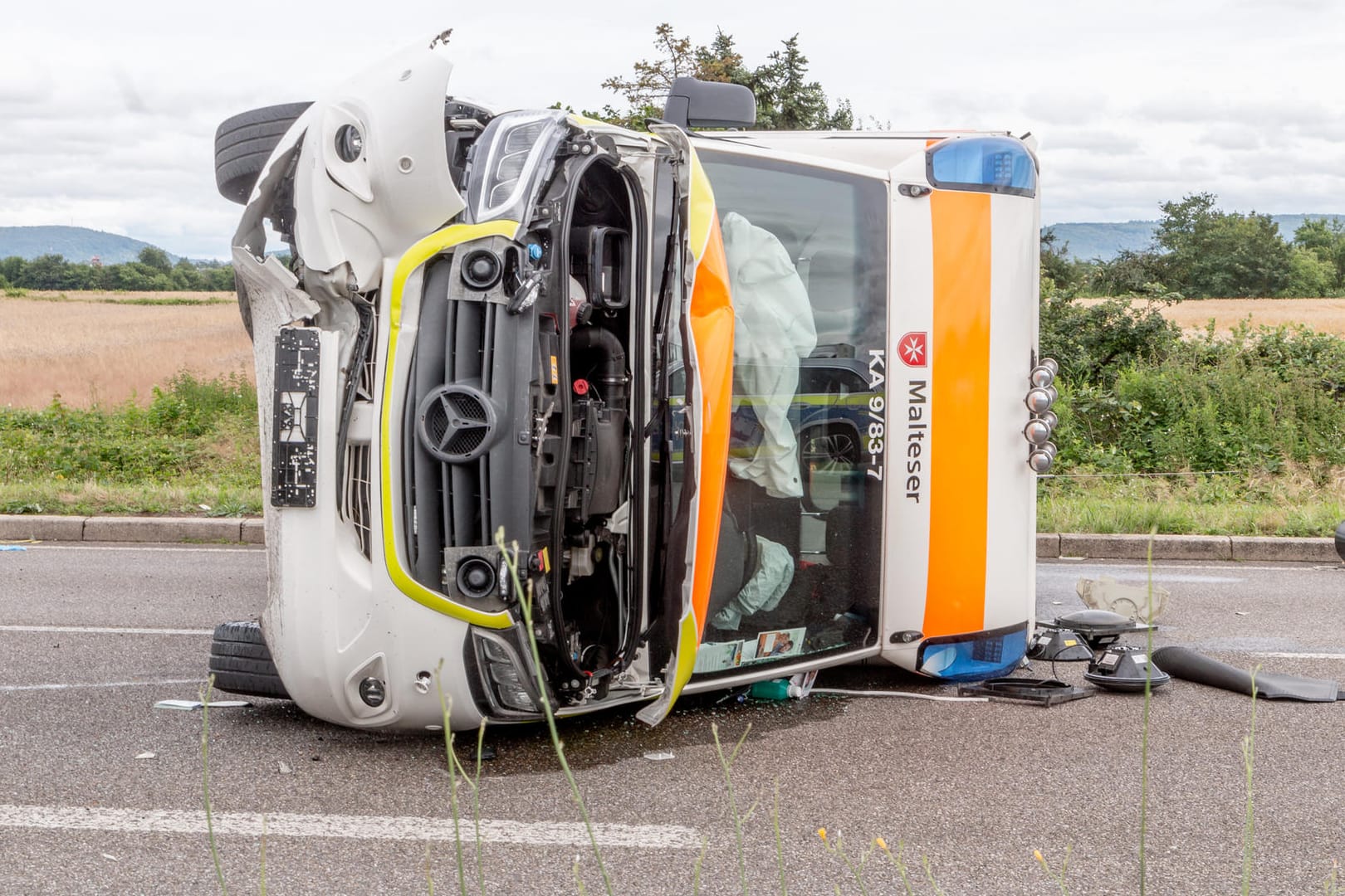 Der umgekippte Rettungswagen liegt nach dem Unfall schwer beschädigt auf der Straße: Vier Menschen wurden bei dem Zusammenstoß verletzt.