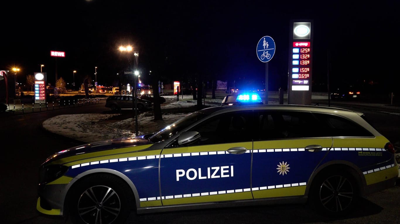 Ein Polizeiauto vor einer Tankstelle (Archivbild): Ein Mann wurde mit einem Messer im Gesicht verletzt.