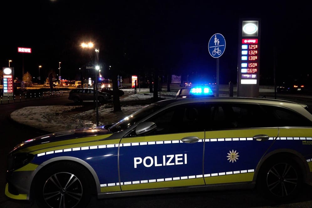 Ein Polizeiauto vor einer Tankstelle (Archivbild): Ein Mann wurde mit einem Messer im Gesicht verletzt.