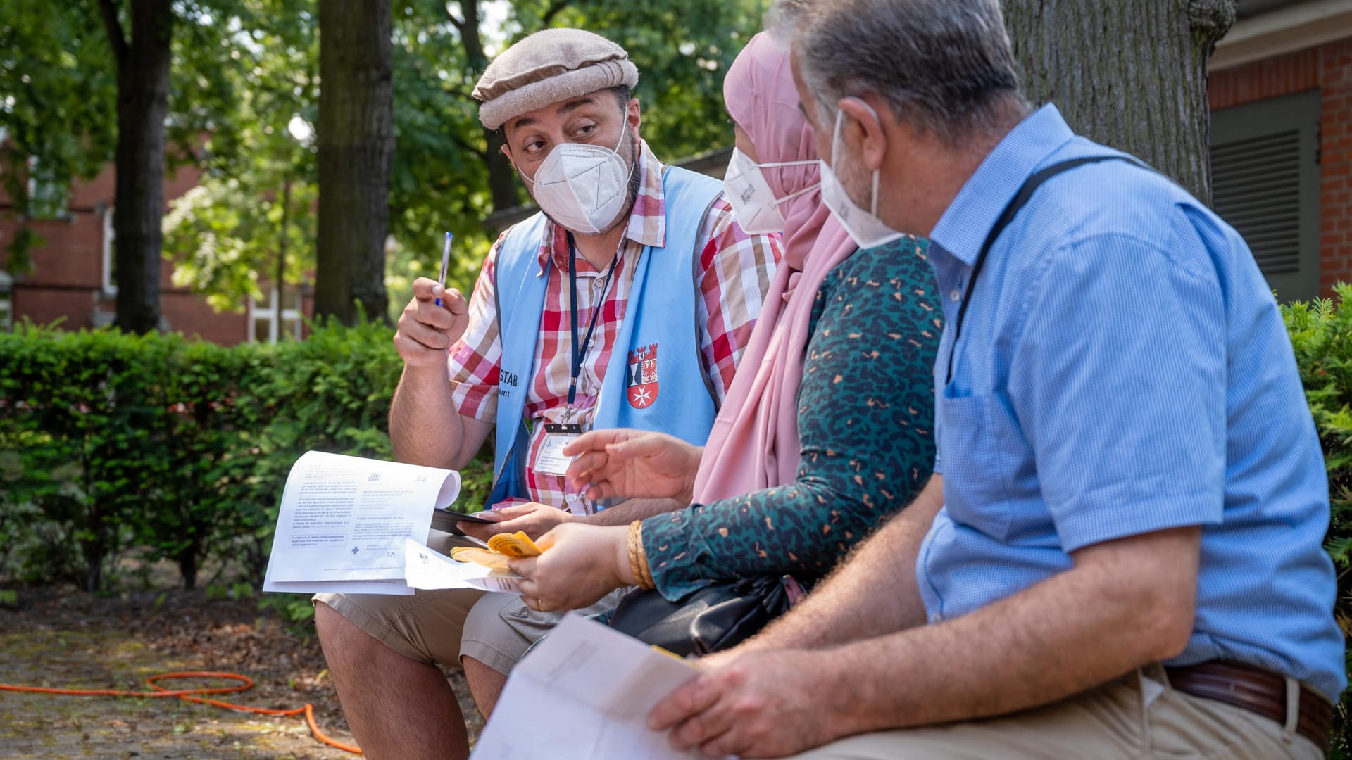 Taman Noor (l), Leiter des Interkulturellen Aufklärungsteams für Berlin Neukölln (IKAT), berät bei einer Impfstelle auf dem Gelände des Bezirksamts Neukölln Menschen zum Thema Corona-Schutzimpfung: Das Team bietet Beratungen in 13 Sprachen an. Taman Noor (l), Leiter des Interkulturellen Aufklärungsteams für Berlin Neukölln (IKAT), berät bei einer Impfstelle auf dem Gelände des Bezirksamts Neukölln Menschen zum Thema Corona-Schutzimpfung: Das Team bietet Beratungen in 13 Sprachen an.