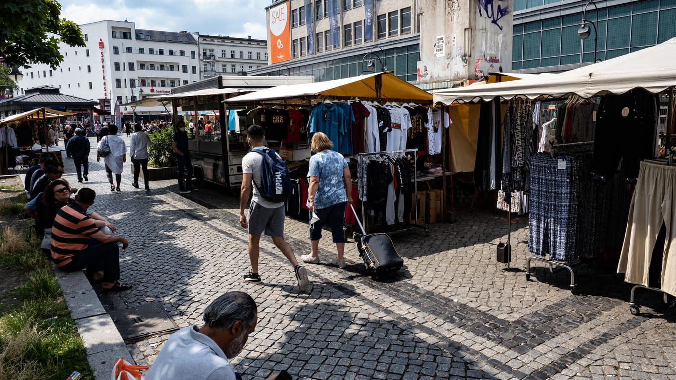 Menschen gehen an den Marktständen auf dem Hermannplatz in Neukölln vorbei: Der Bezirk sucht weiter nach Möglichkeiten, das Infektionsgeschehen in dem Berliner Stadtteil positiv zu beeinflussen.