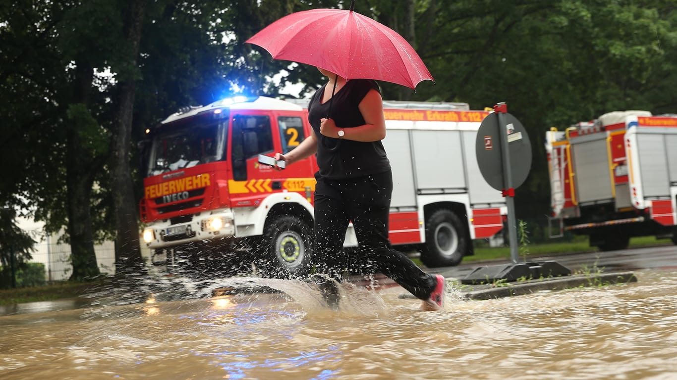 Eine Frau auf der Morper Allee in Erkrath: Ein schweres Unwetter hat in der Stadt für Hochwasser gesorgt.