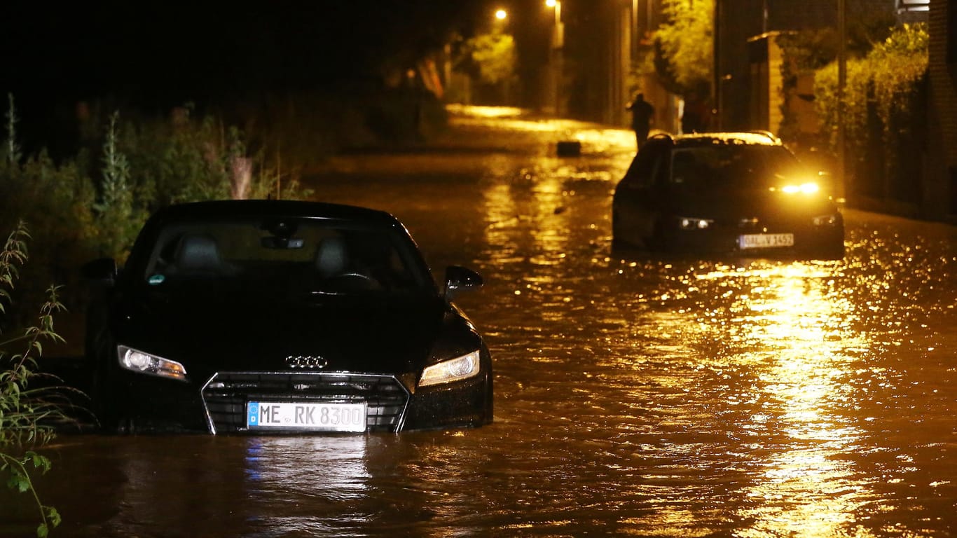 Hochwasser in Erkrath am Mittwoch: Zwei Autos stehen auf einer nach Starkregen überfluteten Straße.