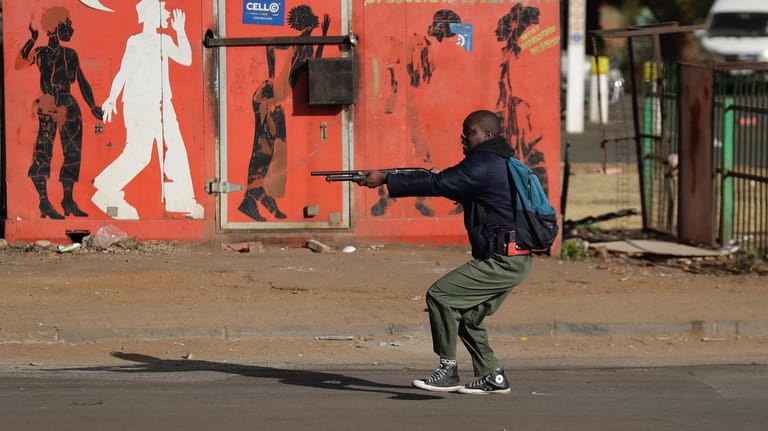Soweto: Bewaffnete Polizisten in Zivil versuchen Plünderer zu vertreiben.