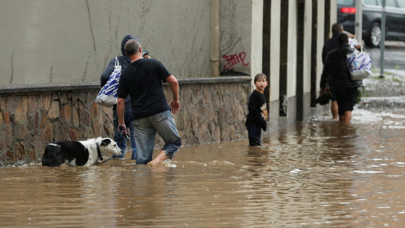 Menschen bahnen sich den Weg durch überflutete Straßen in Hagen. Dort hatten Wassermassen für Chaos gesorgt.
