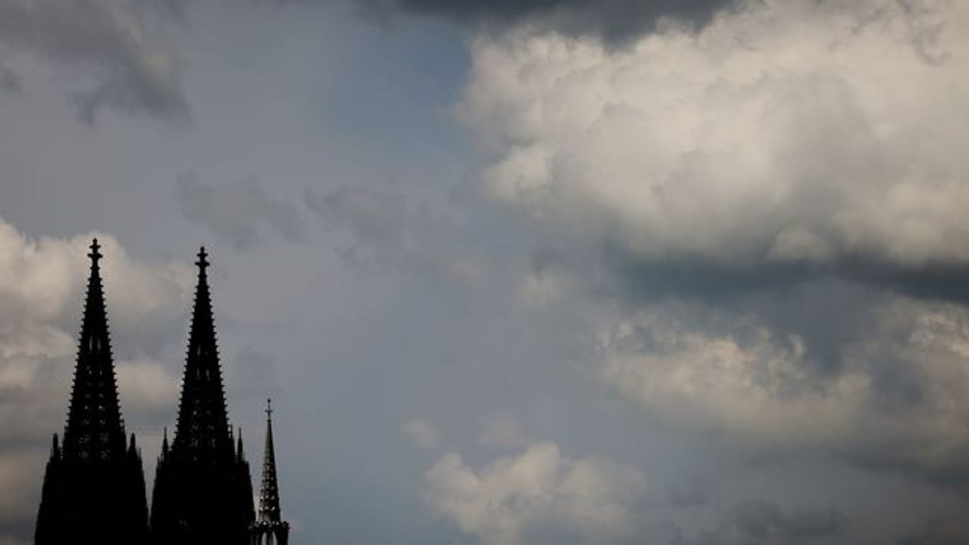 Wolken ziehen am Dom vorbei (Archivbild): 2021 könnten die Austrittszahlen im Erzbistum Köln deutlich höher liegen.