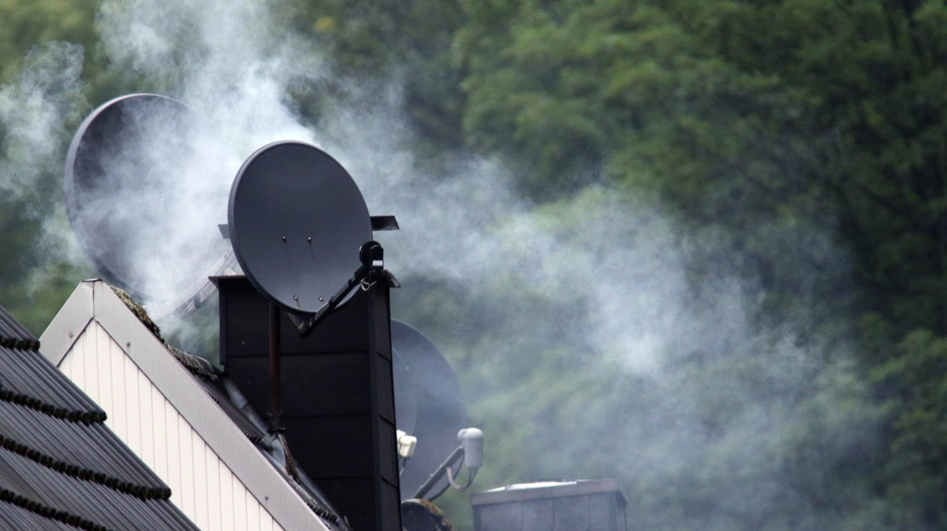 Rauchender Kamin (Symbolbild): Kamine und Kachelöfen sollen nicht mehr die Luft in Wohngebieten verpesten.