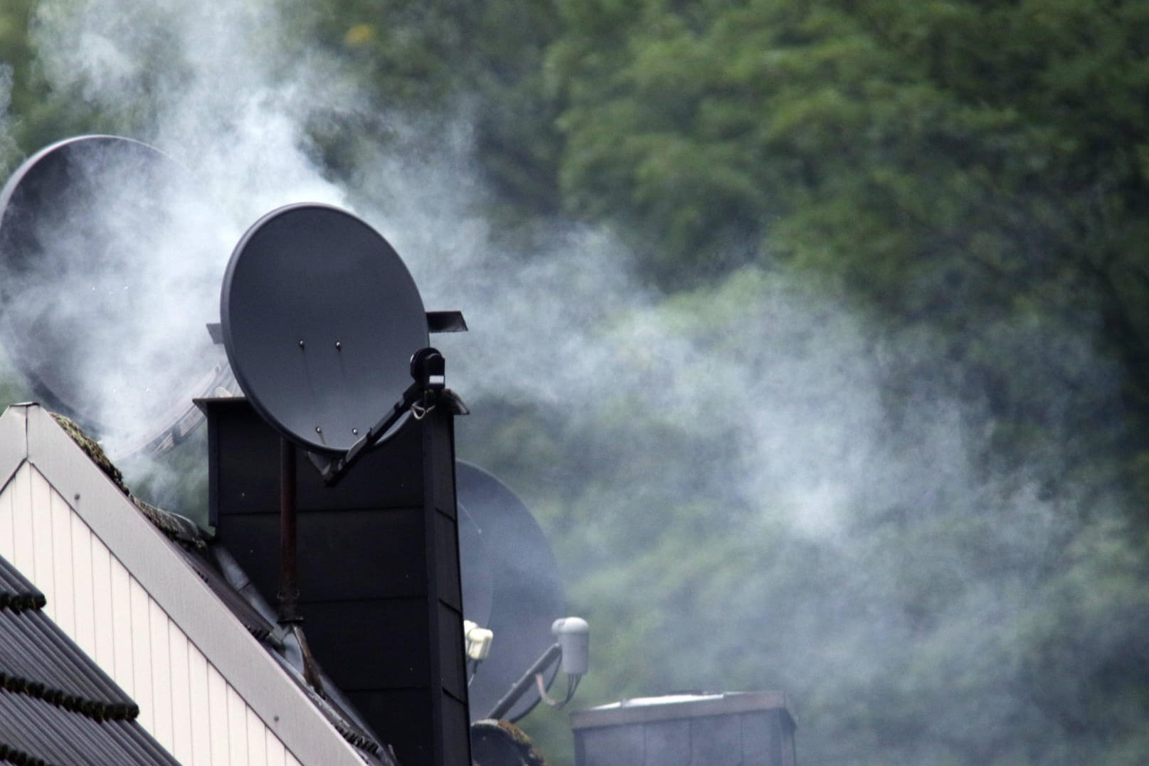 Rauchender Kamin (Symbolbild): Kamine und Kachelöfen sollen nicht mehr die Luft in Wohngebieten verpesten.