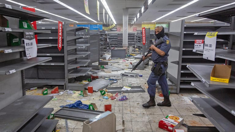 Johannesburg: Ein Polizist geht durch ein geplündertes Geschäft.
