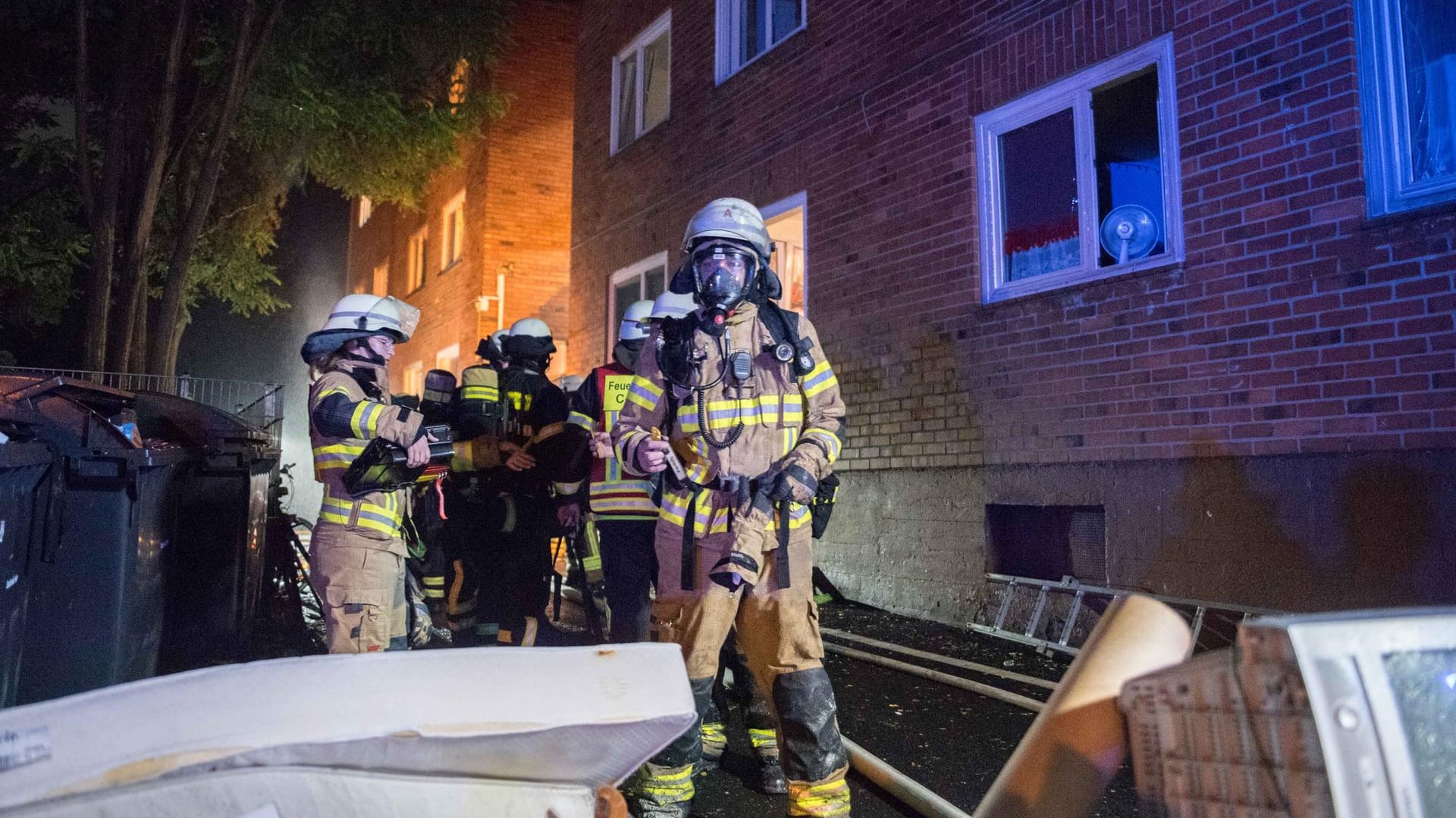 Einsatzkräfte der Feuerwehr vor der Unterkunft, in der es brannte: Ein Bewohner wurde bei dem Feuer schwer verletzt, ein weiterer leicht.