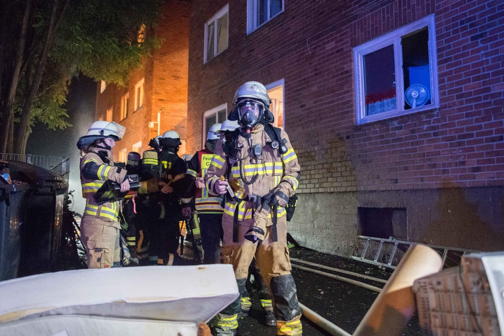 Einsatzkräfte der Feuerwehr vor der Unterkunft, in der es brannte: Ein Bewohner wurde bei dem Feuer schwer verletzt, ein weiterer leicht.