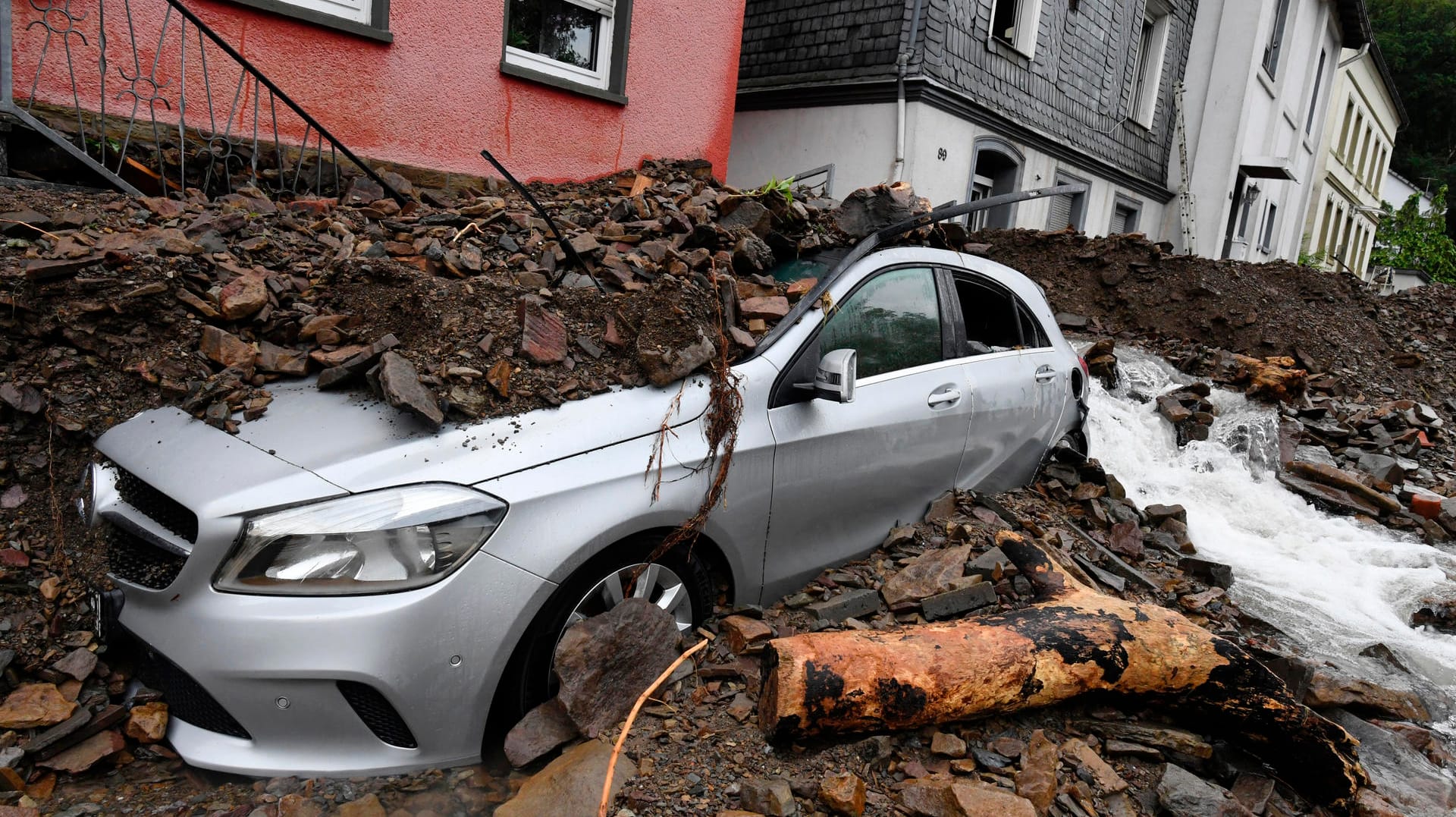 Ein Auto ist in Hagen vom Schutt bedeckt. Die Stadt im Ruhrgebiet ist vom Hochwasser stark betroffen.