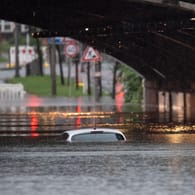 Eine überflutete Bahnunterführung in Köln: Nur noch das Dach dieses Autos ist zu sehen, so hoch steht das Wasser.