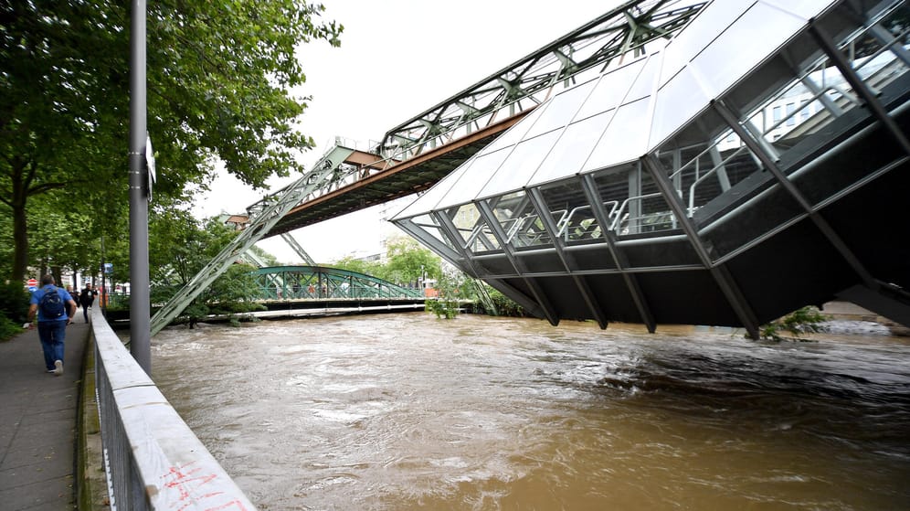 Eine Station der Schwebebahn über der Hochwasser führenden Wupper: Katastrophen-Apps können vor Unwetter warnen.