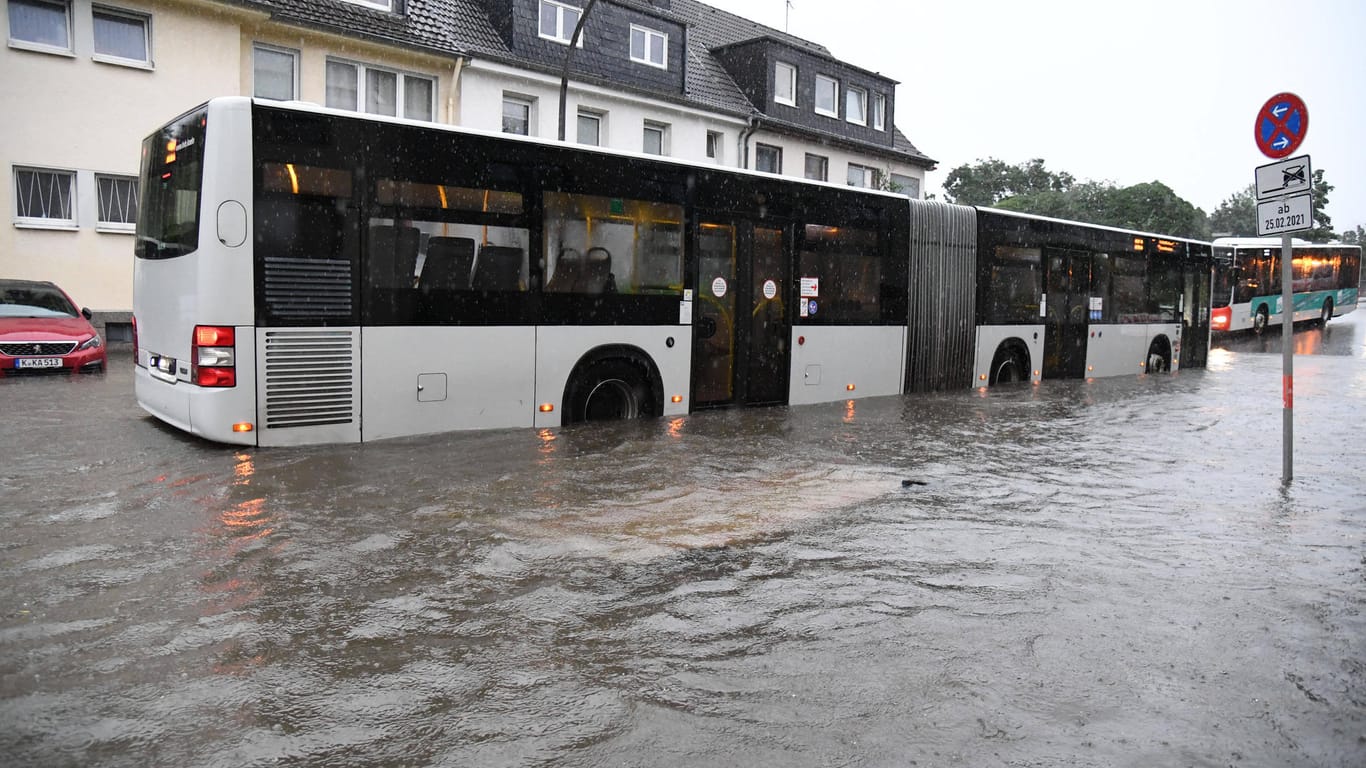 Ein Bus der KVB fährt auf einer überfluteten Straße in Müngersdorf: In der gesamten Stadt und Umgebung kommt es zu Beeinträchtigungen im Verkehr.