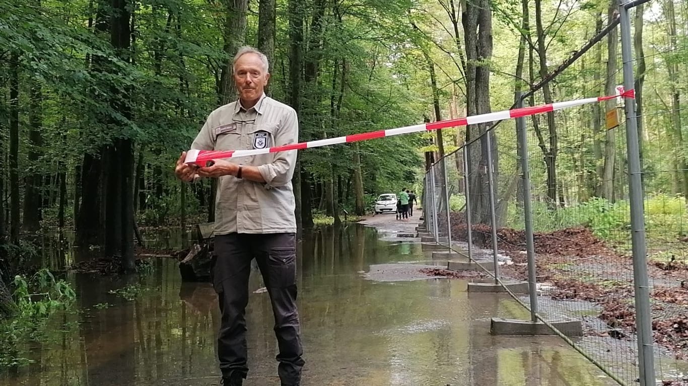 Markus Bouwman mit einem Flatterband: Der Leiter der Kölner Forstverwaltung sichert einen überfluteten Weg am Damwildgehege ab.