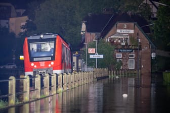 Ein Zug in den Wassermassen in Rheinland-Pfalz. Die Unwetter beeinträchtigen auch den Bahnverkehr in anderen Bundesländern.